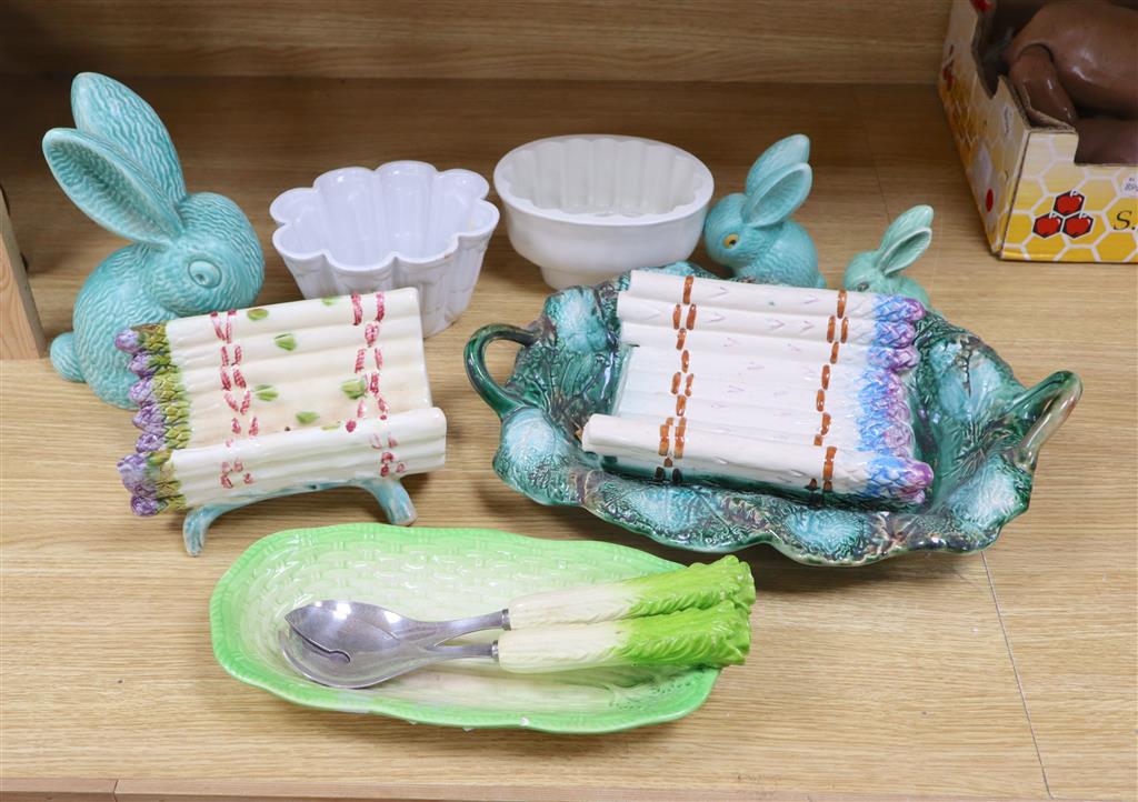 A Majolica style asparagus stand, a dish, graduated rabbits, a celery dish, and two jelly moulds, largest width 40cm